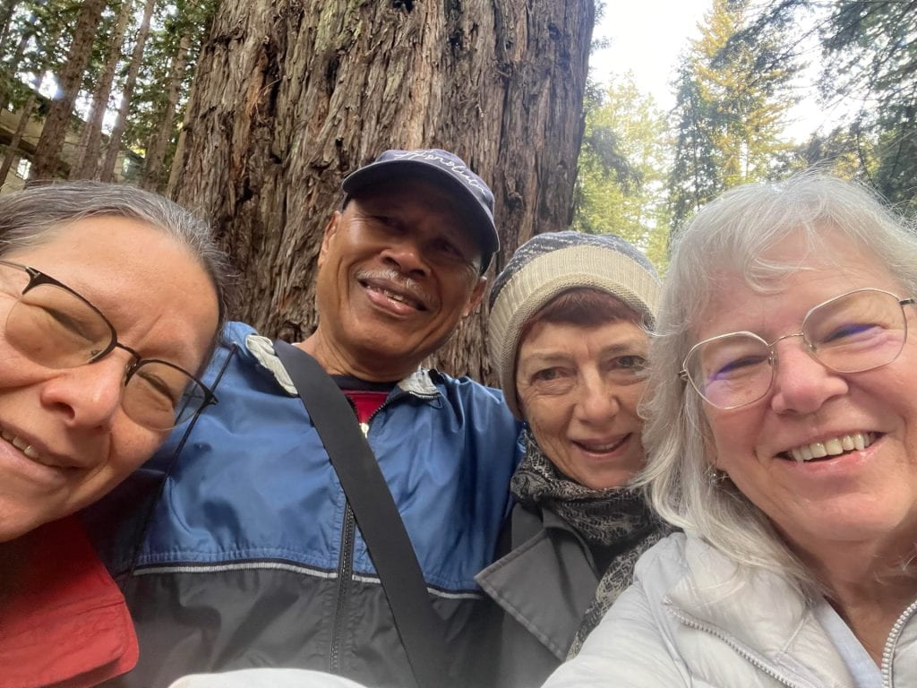 A selfie of four people in a forest